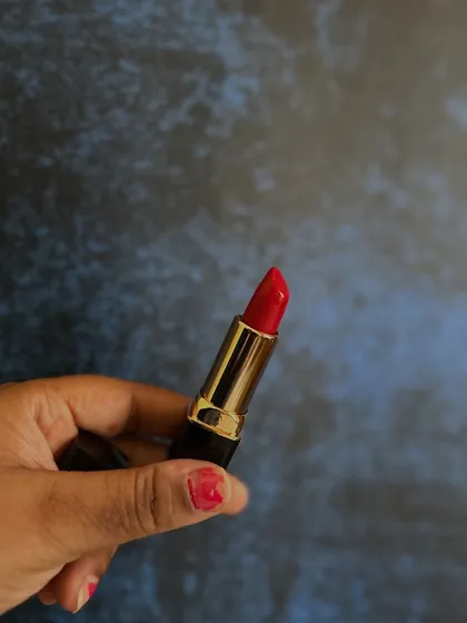 A close-up of the vibrant red lipstick. The color is rich and the formula is creamy, gliding on smoothly for a comfortable wear.