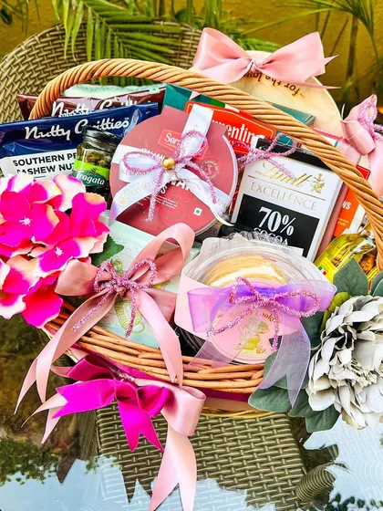 I was thrilled to create this custom birthday hamper for Indian cricketer Bhuvneshwar Kumar. This wicker basket is filled with a curated selection of gourmet treats, including dark chocolate, savory nuts, and other favorites, all elegantly wrapped with pink and lilac ribbons.