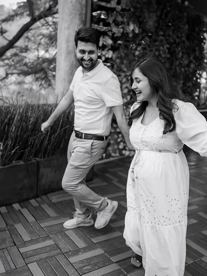A fun, candid moment of the couple laughing and walking together. This black and white photo captures the pure joy and energy of their relationship.