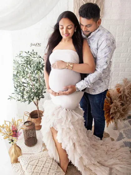 This couple's portrait showcases the beautiful ruffled gown and the loving way the dad to be holds the baby bump. A truly beautiful memory.