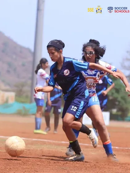 Another action shot of Prisha Patel on the move, evading a defender. Her ability to maintain possession under pressure is a key attribute we develop in our midfielders.