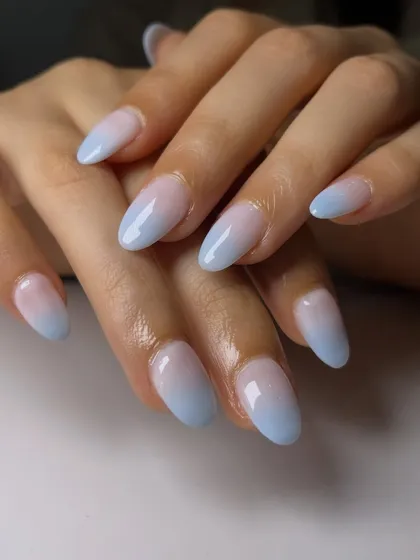 A perfect ombré is all about a seamless blend. This soft fade from a natural pink base to a dreamy baby blue tip is a beautiful example of a clean, elegant gradient on almond-shaped nails.