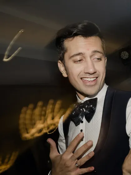 The groom's expressive face, caught in a moment of dance and laughter, perfectly capturing the spirit of the Sangeet.