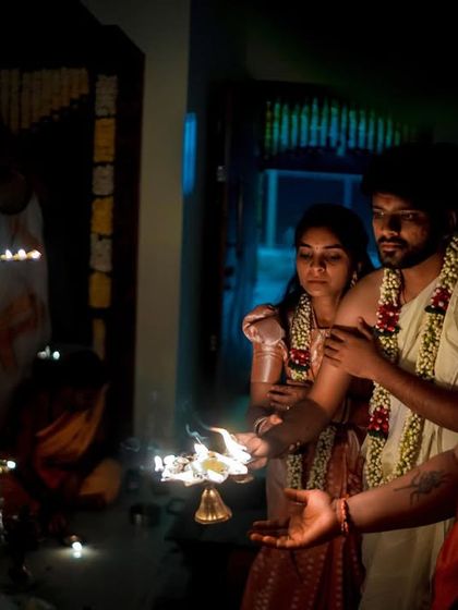 A dramatic, low light shot of a couple participating in a lamp-lit ceremony. We are experts in handling challenging lighting to create beautiful images.