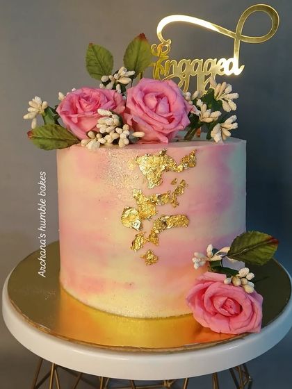 A lovely pink marble effect engagement cake with fresh roses and gold leaf.