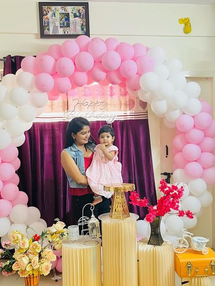 Holding my daughter Aarya in front of her birthday decorations. She is my little Aaru puti.