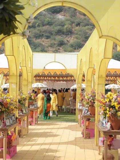 The entry passage for the Haldi was a narrow space we transformed with yellow arches inspired by Rajasthani architecture. Leaving the ceiling open to the sky made the walkway feel bright and airy.