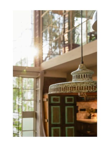 The sunlight catching the edge of the pendant light creates a beautiful flare, highlighting the airy, open feel of the loft.