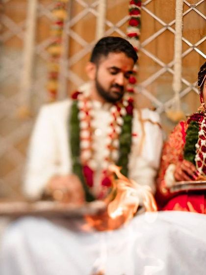 The bride and groom performing a ritual during their wedding ceremony, their focus and devotion beautifully captured.