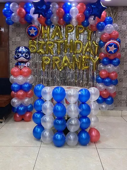 We bring themes to life! This Captain America decoration setup, complete with a balloon arch, themed pillars, and a custom name banner, created an epic superhero backdrop for Praney's birthday.