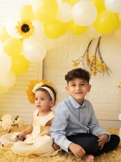 Siblings sitting together during a first birthday shoot. These photos become cherished memories of their relationship as they grow.