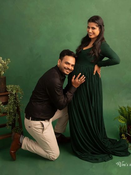 A classic, fun maternity pose. The father-to-be listens to the baby's kicks, sharing a happy and intimate moment with his partner.