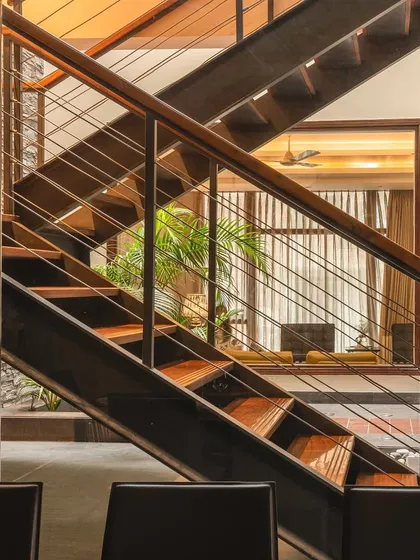 This view highlights the fluid, transitional layout of the home. The open staircase allows natural light to fill the residence while adding another architectural dimension to the space.