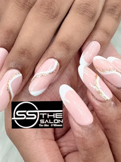 This is an example of an elegant and modern nail extension design. It features a soft pink base with a contemporary twist on the classic French tip, accented by a delicate swirl of gold glitter for a sophisticated finish.
