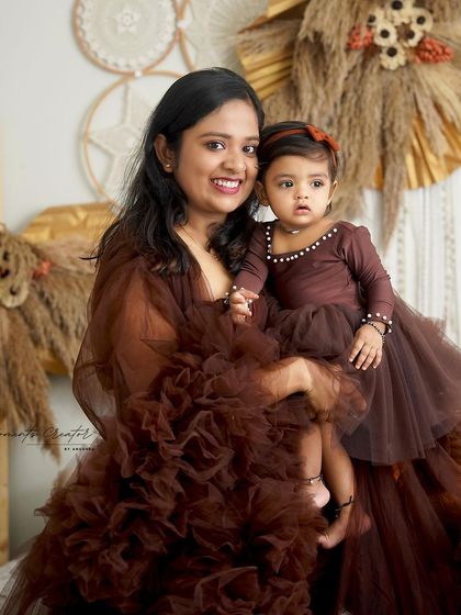 A sweet mother-daughter moment. Twinning in brown, the mother holds her little girl close, showcasing their loving bond.
