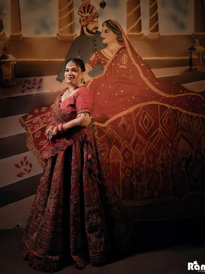 A unique bridal portrait where the bride is posed in front of a traditional painting of a royal couple. This creative composition connects her modern bridal look with a sense of history and artistry.
