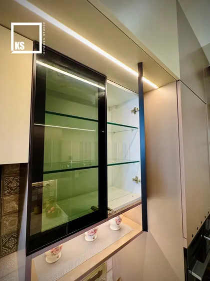 A detailed look at the profile-lit glass cabinet doors. This feature not only illuminates the items inside but also adds a layer of ambient light to the entire kitchen.