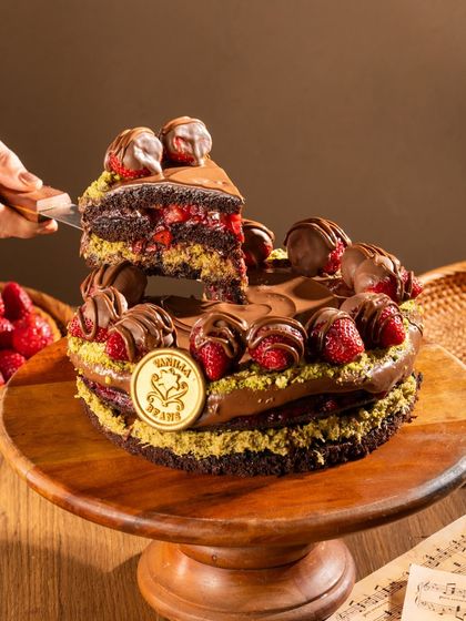 A slice is served from our Krispy Kunafa Nutella Strawberry Cake. This creation blends Middle Eastern craftsmanship with modern indulgence for a truly unique flavor.