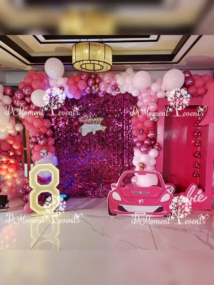 Come on Barbie, let's go party! This vibrant pink Barbie-themed setup includes a sequin wall, a Barbie box photo booth, and a pink car prop for the ultimate glam celebration.