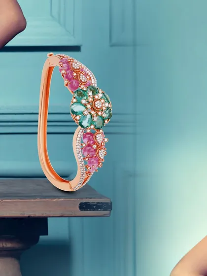 In this bridal kada, threads of rose gold entwine with the brilliance of diamonds and colorful gemstones. It is a masterpiece of craftsmanship designed to adorn a bride's wrist with elegance.