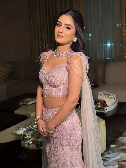 She looks radiant and confident in her pastel couture. The makeup enhances her youthful features and gives her an incredible glow.