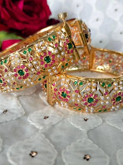 My classic जड़ाऊ कंगन (Jadau Kangan). These openable bangles feature a timeless floral design with red and green stones, perfect for any traditional occasion.