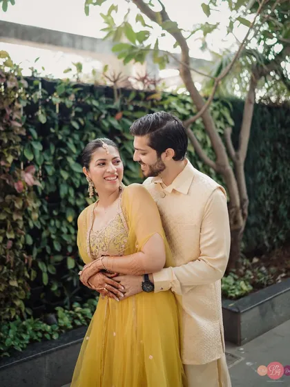 A warm embrace, with both of them glowing in coordinated outfits. This is the comfortable, happy love we aim to capture.