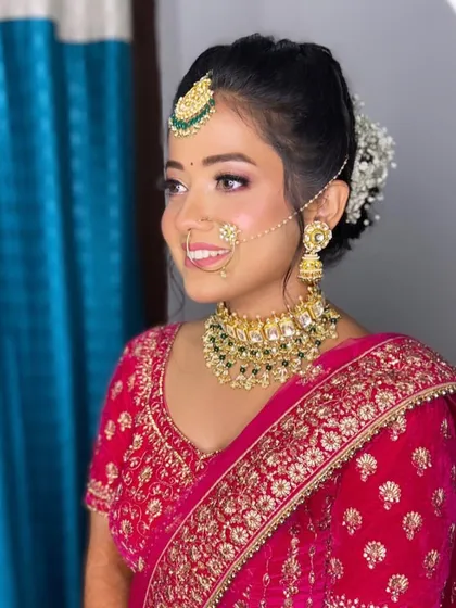 Neha's smile says it all. For her bridal look, we chose a fresh and radiant style with pink tones on the eyes and cheeks to complement her beautiful pinkish-red lehenga.