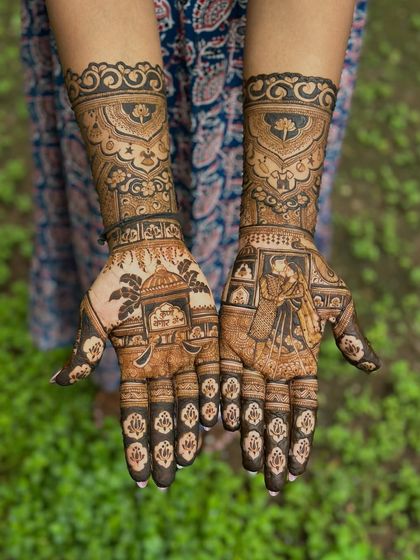 A full view of the arms, showcasing the beautiful blend of personal storytelling and traditional henna art for a very special occasion.