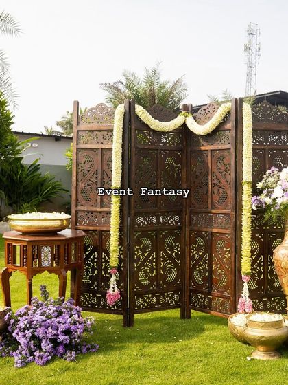Another view of the outdoor setup, showing how the traditional wooden screen and brass props create a beautiful, minimalist focal point on the open lawn.