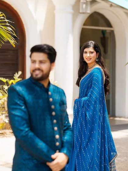 A creative portrait using depth of field to focus on the bride while the groom is in the foreground. This technique adds an artistic, story-driven element to the couple's gallery.