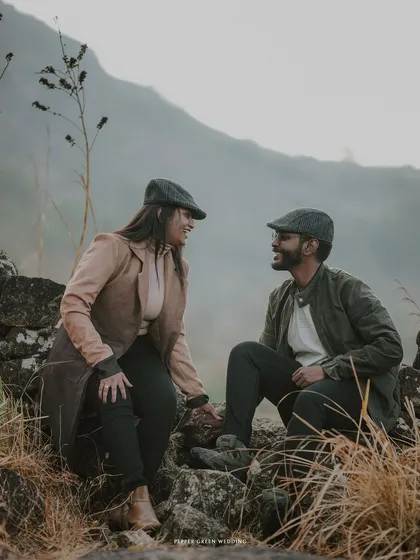 A candid moment of conversation and laughter, set against the rustic beauty of a stone wall during their vintage-style pre-wedding shoot.