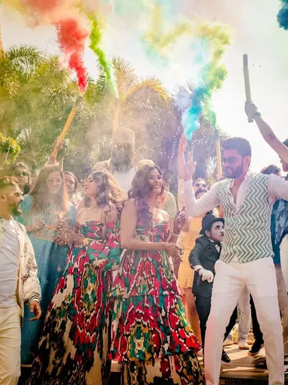 The couples and their friends celebrating with color smoke, creating a stunning visual and a high-energy atmosphere.