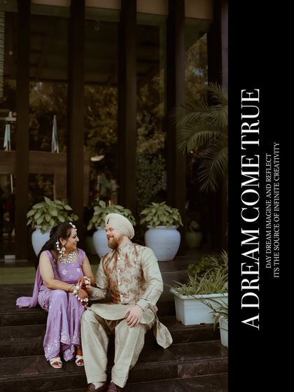 "A dream come true." The couple shares a quiet moment on the steps of a modern building, their traditional attire contrasting beautifully with the contemporary setting.