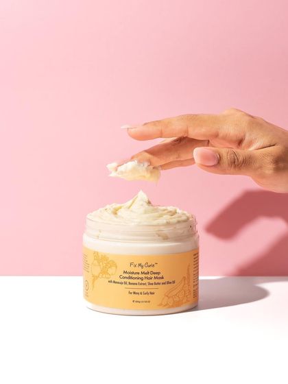 A close-up texture shot that adds a human touch. The hand scooping the rich hair mask allows viewers to imagine the feeling of the product, making it much more enticing.