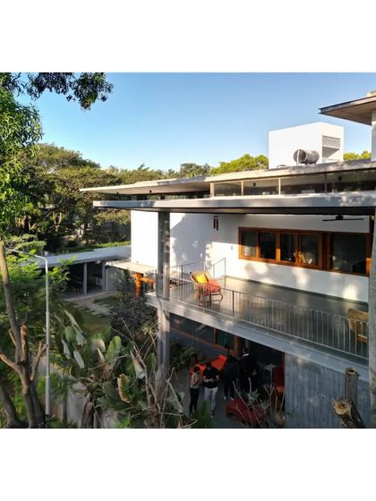 The home viewed from a distance, showing how the horizontal lines of the canopies help the structure settle into its verdant site.