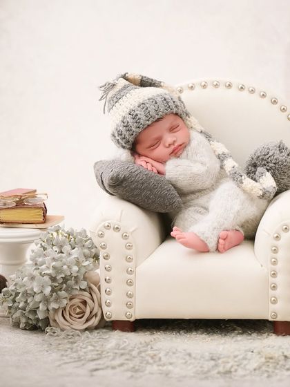 This little one is styled as a sleepy gnome, dozing in a miniature armchair with tiny books and mushrooms to complete the whimsical scene.