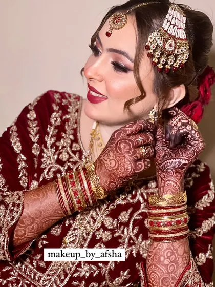 A happy bride is the most beautiful bride! Her smile says it all. For this look, we chose a classic red lip and soft, shimmery eyes, with her hair pulled back into an elegant bun adorned with red roses.
