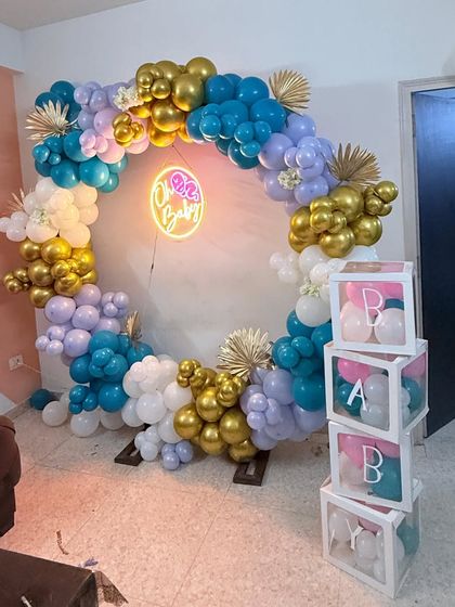 A full view of the "Oh Baby" baby shower backdrop. The circular balloon arch is complemented by "BABY" blocks filled with matching balloons, creating a complete and stylish photo zone.