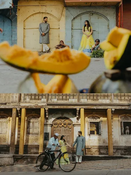 A creative collage from a Nashik pre-wedding shoot, using foreground elements like a pumpkin to frame the couple in a street market setting.