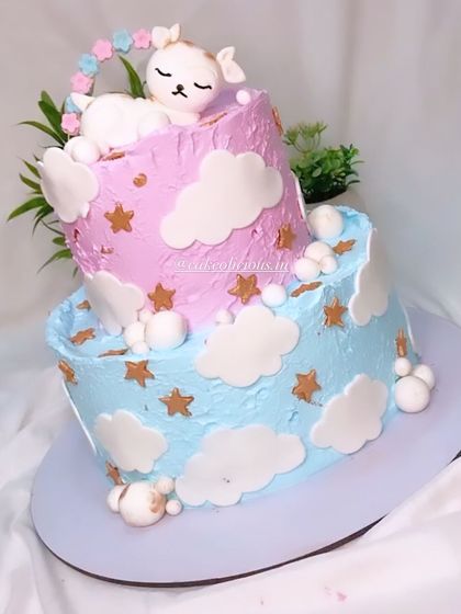 A side view of the dreamy two-tier baby shower cake, showing the delicate cloud and star details.