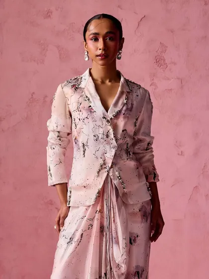 A different take on the fusion look. This ensemble features a draped skirt paired with a printed blazer with sleeves, offering a more formal yet equally stylish option.