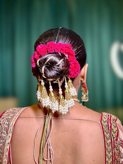 Another angle of the pink floral bun, highlighting the intricate gold thread work that adds an extra touch of desi glam.