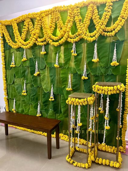 For a truly traditional feel, we created this backdrop using fresh banana leaves. The hanging marigold and tuberose strings add a classic touch, perfect for an authentic South Indian wedding ceremony.