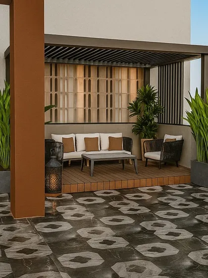 This Punjabi Bagh terrace design combines a raised wooden deck and pergola with bold, patterned flooring. The tall planters create a natural green screen, offering privacy and a lush backdrop for the cozy seating area.
