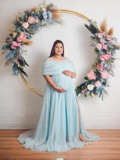 This mom-to-be looks like a goddess in our light blue gown, framed by a custom floral hoop. This setup creates such a wonderfully romantic and ethereal vibe for your maternity photos.