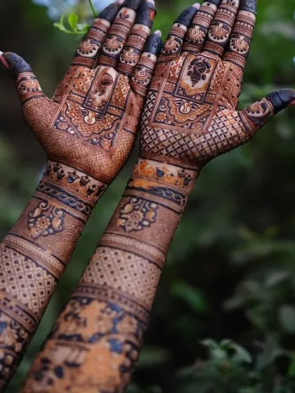The rich, dark stain of our henna is evident in this photo, taken after the paste has been removed. The intricate patterns on the back of the hands are beautifully defined.