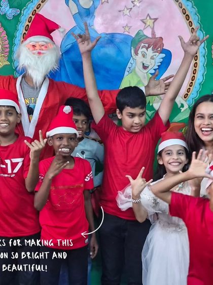 Thanks for making this season so bright and beautiful. Children and volunteers, some dressed as Santa, celebrate Christmas with energy and excitement at our East Meets West Library.