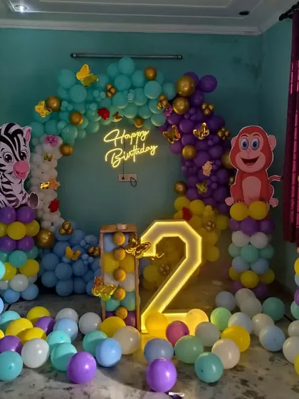 I can bring any theme to life, like this vibrant jungle-themed party for a second birthday. The setup includes a full balloon ring, large cutouts of jungle animals like a lion, zebra, and monkey, and a light-up marquee number.