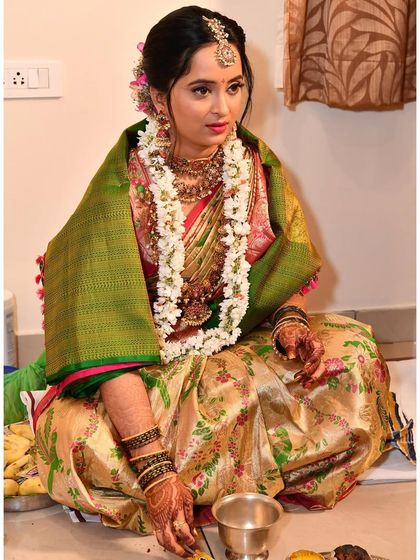 This bride is ready for her Gouri Pooja. The makeup is traditional, with a focus on defined eyes and a radiant complexion, perfect for the ceremony.